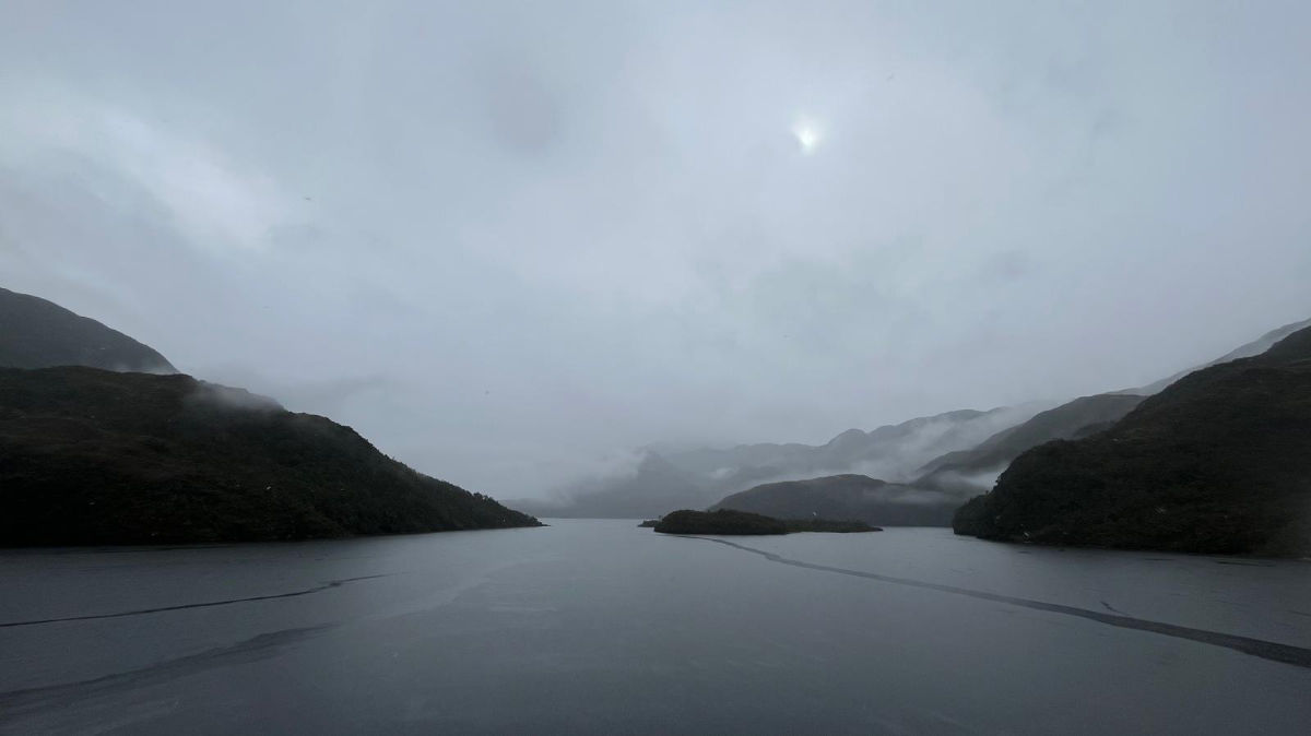 Flat sea and fjords on a rainy day, as seen from the ferry