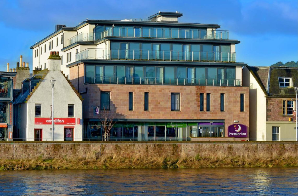 Premier Inn Inverness, modern multi-storey hotel with glass balconies overlooking the river.