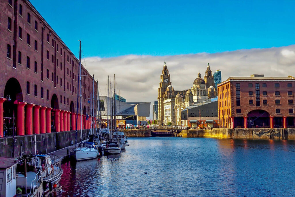 View of Albert Dock in Liverpool with moored boats and historic waterfront buildings.